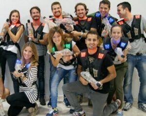 Un grupo mira a la cámara desde el interior, equipados con chalecos y pistolas láser para una partida épica. ¡Su experiencia "Oferta: 2 partidas de Laser Tag en Alfafar" es la comidilla de Alfafar!. - ForTwo - Planes para parejas