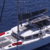 Vista aérea del Paseo en Yate por Tenerife, un catamarán blanco con equipamiento rojo, navegando elegantemente en las profundas aguas azules cerca de Tenerife. - ForTwo - Planes para parejas