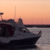 Un "Paseo en barco romántico por Bilbao" al atardecer revela un cielo rosa y naranja, resaltando la costa a lo lejos. - ForTwo - Planes para parejas