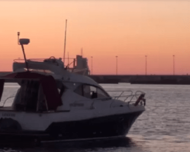 Un "Paseo en barco romántico por Bilbao" al atardecer revela un cielo rosa y naranja, resaltando la costa a lo lejos. - ForTwo - Planes para parejas