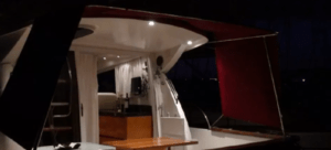 El "Paseo en barco romántico por Bilbao" ofrece un acogedor interior de yate, donde la cálida iluminación realza el encanto íntimo alrededor de la mesa y la cocina americana. - ForTwo - Planes para parejas