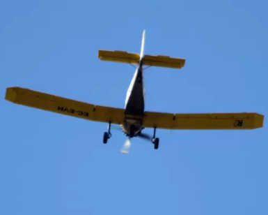 Un pequeño avión amarillo planea bajo un cielo azul claro, ofreciendo la experiencia "Piloto por un día en Atarfe" que captura la emoción de volar. - ForTwo - Planes para parejas
