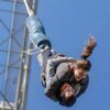 Dos personas disfrutan de un Salto Bungee Tándem en Lloret de Mar, colgando boca abajo contra un cielo azul claro. - ForTwo - Planes para parejas