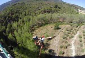 Experimenta una descarga de adrenalina sobre el exuberante paisaje de Valencia con el "Salto de puente en Valencia con vídeo: ¡vive la adrenalina en pareja!" rodeado de bosques y cielos despejados. - ForTwo - Planes para parejas