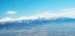 Vista aérea de las montañas nevadas cerca de Granada bajo un cielo azul claro, experimentada durante un emocionante Vuelo en Avioneta por Granada. - ForTwo - Planes para parejas