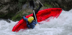 Alguien que lleva un casco amarillo vuelca en el "kayak por el río Genil" en las agitadas aguas bravas del río. - ForTwo - Planes para parejas