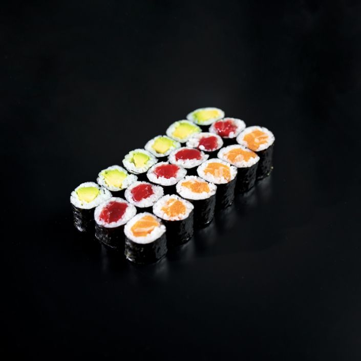 La "Cena Japonesa en Más que Sushi" ofrece una variedad de rollos de sushi con rellenos coloridos, cuidadosamente dispuestos sobre una superficie negra. Cada vibrante pieza es una obra maestra llena de sabor. - ForTwo - Planes para parejas