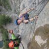 Sonrientes escaladores, un hombre y una mujer, abordan el acantilado rocoso de la Cascada del Sorrosal durante su "Curso de Vía Ferrata en la Cascada del Sorrosal", asegurados con cuerdas y cascos para una aventura llena de emoción y recuerdos inolvidables. - ForTwo - Planes para parejas