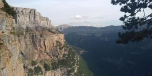 Explora los imponentes acantilados sobre un profundo cañón cerca de Morata de Jalón, salpicados de escasos árboles bajo un cielo despejado, embarcándote en el Curso de vía ferrata en Morata de Jalón. - ForTwo - Planes para parejas