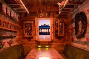 Experimenta el Escape Room Gastronómico en Madrid, con una acogedora sala de madera con decoración rústica y una ventana enmarcada con vistas a una estación de tren iluminada al atardecer, capturando el vibrante ambiente madrileño. Perfecto para quienes buscan una escapada única con un toque gastronómico. - ForTwo - Planes para parejas