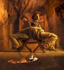 En la emocionante sala de escape Catacumbas en goldenpop, dos hombres vestidos de exploradores están atados espalda con espalda en una cueva, con fuego parpadeando a sus pies: cada movimiento podría revelar secretos o sellar su destino. - ForTwo - Planes para parejas
