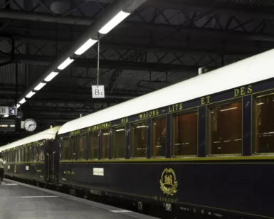 El tren Orient Express descansa sobre una plataforma poco iluminada con sus elegantes vagones antiguos susurrando historias de misterio como "Escapismo y Cluedo en Zaragoza" bajo un techo industrial. - ForTwo - Planes para parejas