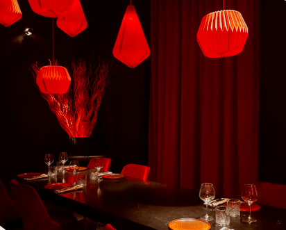 Las luces colgantes rojas proyectan un brillo tenue sobre el comedor, creando una atmósfera impregnada de Parda BCN Una Cita con Encanto en Barcelona, mientras la mesa está bellamente puesta con elegantes vasos y platos. - ForTwo - Planes para parejas