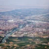 Un paseo en avión revela Zaragoza, España, donde el río Ebro serpentea con gracia entre paisajes urbanos y zonas verdes, con el imponente Moncayo en la distancia. - ForTwo - Planes para parejas