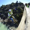 Una persona con equipo de seguridad disfruta del Puenting en Murillo de Gállego desde un puente, mientras otra captura el emocionante descenso desde arriba. - ForTwo - Planes para parejas