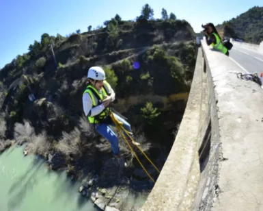 Una persona con equipo de seguridad disfruta del Puenting en Murillo de Gállego desde un puente, mientras otra captura el emocionante descenso desde arriba. - ForTwo - Planes para parejas