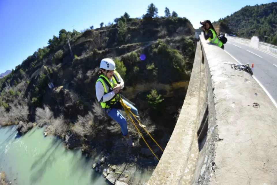 Una persona con equipo de seguridad disfruta del Puenting en Murillo de Gállego desde un puente, mientras otra captura el emocionante descenso desde arriba. - ForTwo - Planes para parejas