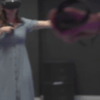Inmerso en la Realidad Virtual en Sapakara BCN, un individuo vestido explora el reino digital con un casco y un controlador de VR, contra un fondo borroso de ensueño. - ForTwo - Planes para parejas