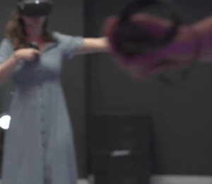 Inmerso en la Realidad Virtual en Sapakara BCN, un individuo vestido explora el reino digital con un casco y un controlador de VR, contra un fondo borroso de ensueño. - ForTwo - Planes para parejas