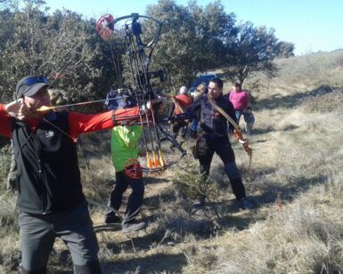 Participando en "Tiro con Arco 3D en Lusía: Una Aventura en Plena Naturaleza", una persona apunta expertamente su arco compuesto en un campo de hierba mientras los espectadores disfrutan del cielo claro y expansivo. - ForTwo - Planes para parejas