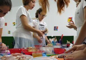 Durante la 👨‍🍳 Gymkana de MasterChef en Zaragoza, los participantes cocinan en parejas en mesas decoradas con cuencos y utensilios vibrantes. 🍽️. - ForTwo - Planes para parejas