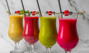 El "Brunch más original en Barcelona" incluye cuatro vibrantes smoothies, cada uno una creación única, en vasos decorados con frutos rojos y menta. Perfecto con el elegante fondo de mármol, esta presentación le dará a su mesa el ambiente de una soleada mañana barcelonesa. - ForTwo - Planes para parejas