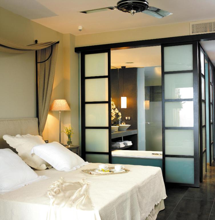 La "Escapada exótica para parejas en Alicante" ofrece un moderno refugio en un dormitorio con una acogedora cama, lujosas almohadas, elegantes puertas corredizas de vidrio esmerilado que dan a un elegante baño y una suave iluminación ambiental, ideal para parejas. - ForTwo - Planes para parejas