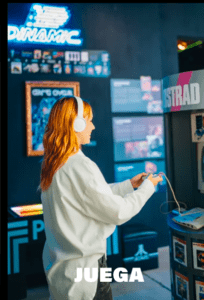 Con los auriculares puestos, un visitante se absorbe en un clásico arcade en el Museo del Videojuego de Madrid, rodeado de luces de neón y carteles retro: un auténtico paso atrás en el tiempo. - ForTwo - Planes para parejas